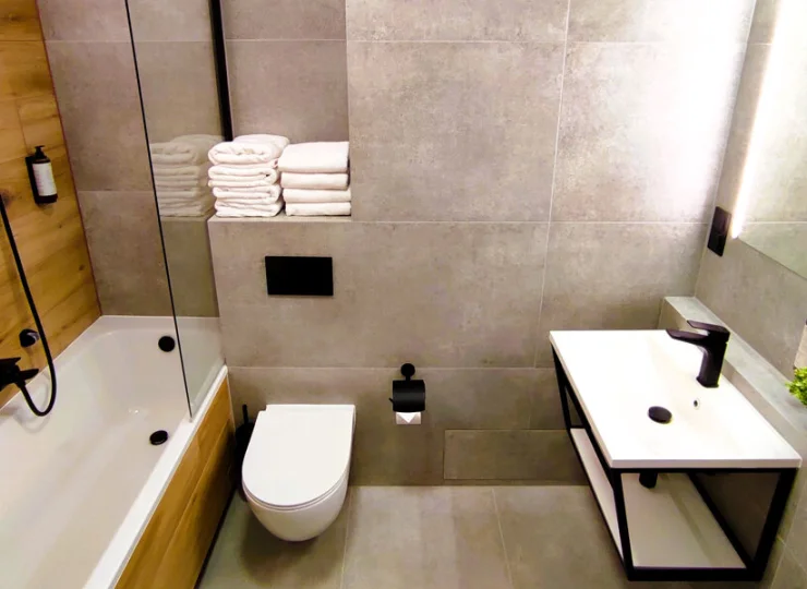 W łazience jest kabina prysznicowa lub wanna z prysznicem