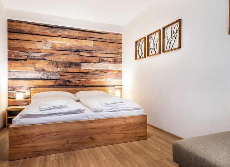 W sypialni apartamentu 2+3 jest podwójne łóżko i rozkładana sofa