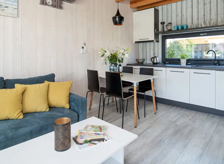 Na parterze mieści się pokój dzienny z kanapą, TV i świetnie wyposażoną kuchnią