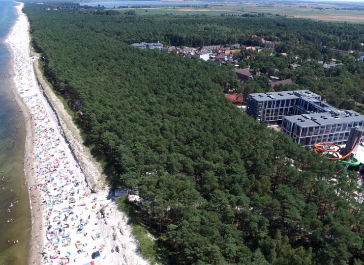 Od szerokiej piaszczystej plaży oddziela go tylko pas sosnowego lasu