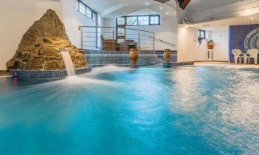 Wewnątrz znajduje się basen z podgrzewaną wodą, przeciwprądem i masażerami