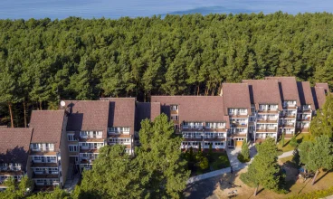 Od szerokiej piaszczystej plaży oddziela go tylko pas sosnowego lasu