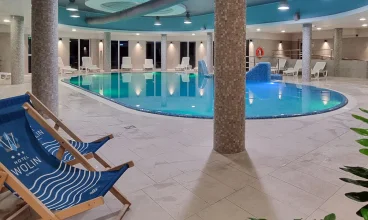 Obok basenu ustawiono leżaki