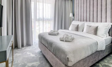 Osobna sypialnia z dwuosobowym łóżkiem w apartamencie deluxe