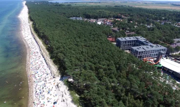 Od szerokiej piaszczystej plaży oddziela go tylko pas sosnowego lasu