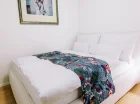 Apartament 1-pokojowy ma wydzieloną sypialnię za kącikiem TV