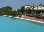 Wokół basenu ustawiono leżaki pozwalające na relaks
