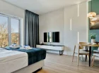 Ten apartament ma pokój z łóżkiem i aneksem kuchennym