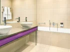 Łazienka apartamentu superior z wanną i dwiema umywalkami