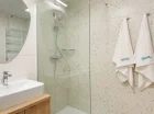 Oprócz pralki w łazience jest prysznic, suszarka do włosów, kosmetyki