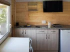 W aneksie kuchennym jest lodówka, płyta kuchenna, czajnik elektryczny