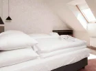 Sypialnia na wyższej kondygnacji ma skośny dach