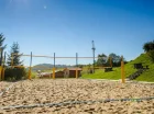 Z kortem tenisowym sąsiaduje boisko do siatkówki plażowej