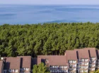 Od szerokiej piaszczystej plaży oddziela go tylko pas sosnowego lasu