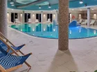 Obok basenu ustawiono leżaki