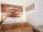 W sypialni apartamentu 2+3 jest podwójne łóżko i rozkładana sofa