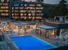 Basen i budynek Aminess Younique Vollo Residence po zachodzie słońca