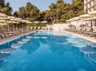 Hotel posiada zewnętrzny basen otoczony parasolami i leżakami