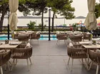 Obok basenu jest restauracyjny taras ze stolikami
